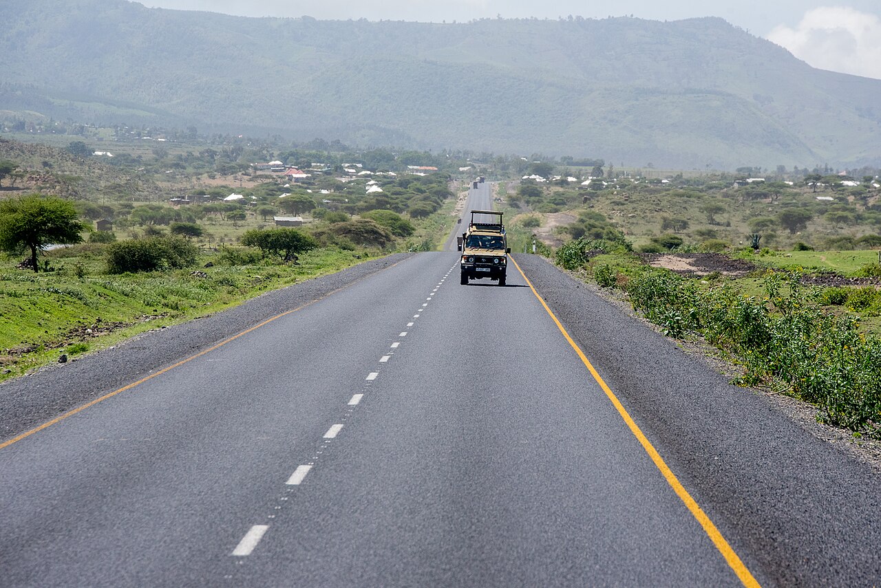 Tourism vehicle travelling on a road towards Serengeti National Park