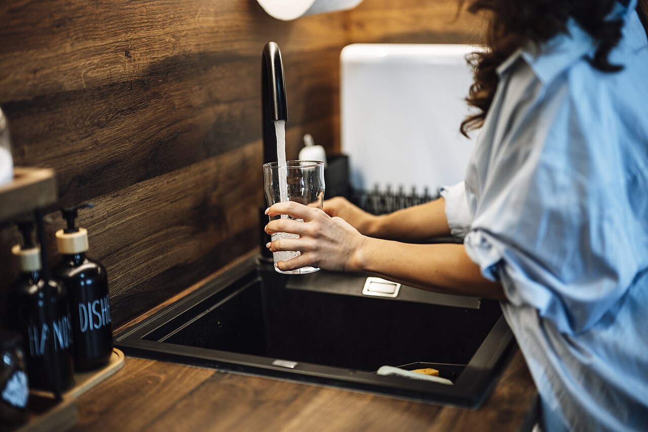 Illustrative photograph of someone filling a glass from a tap outside Tanzania